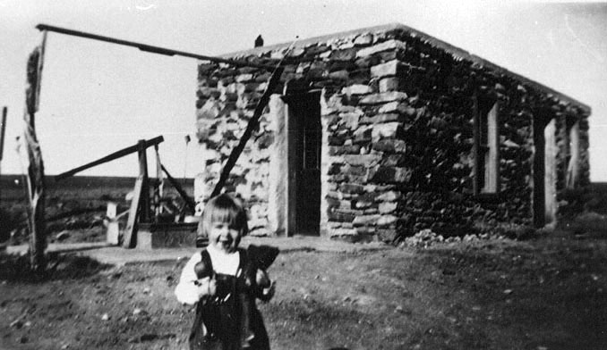 <adrienne with doll in front of little rock house wash house the best picure of the little rock house>