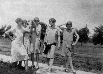 <group of girls cutting up johnie wearing a sash>