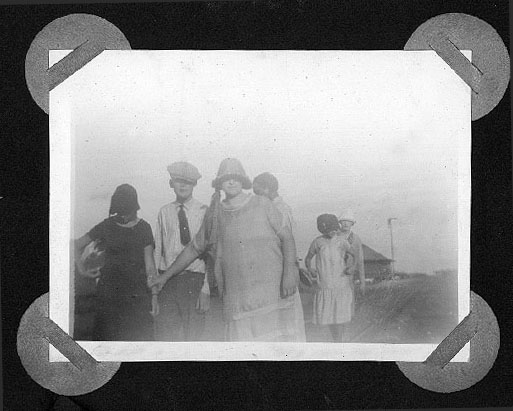 <group of people including young man wearing a golf cap and tie>