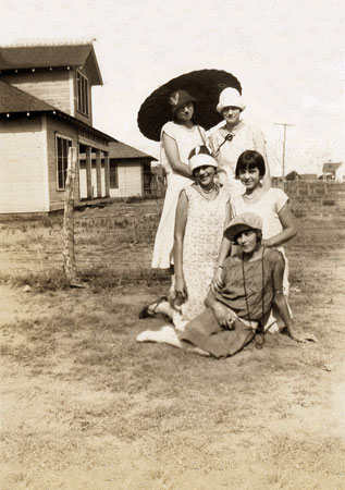 <five ladies in posed group one lady with an umbrella>