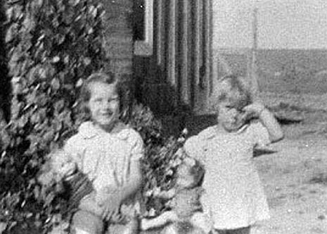 <donna and adrienne playing with dolls front yard of ranch house>