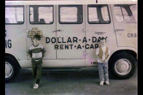 <todd cassan curt cassan standing by dollar rent a car airport shuttle>